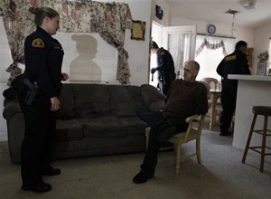 San Bernardino County Probation Officer Marshawn Etchepare arrests parolee Kenneth Lucas for the second time in months after he was released just 60 days into a six-month sentence, during a night probation compliance sweep in Apple Valley, Calif.