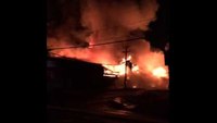 Wall collapse takes out power lines at burning building