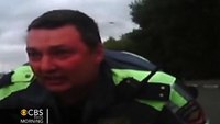 Russian police officer clings to hood of car