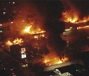 This April 29, 1992 file photo shows several buildings in a Boys Market shopping center fully engulfed in flames before firefighters can arrive as rioting erupted in South-Central Los Angeles. The acquittal of four police officers in the Rodney King case sparked rioting that spread across the city and into neighboring suburbs. Cars were demolished and homes and businesses were burned. Before order was restored, 55 people were dead, 2,300 injured and more than 1,500 buildings were damaged or destroyed.