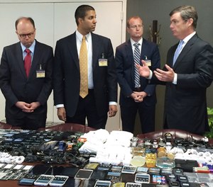 In this photo made available by the South Carolina Department of Corrections on Wednesday, April 6, 2016, their director, Bryan Stirling, right, showing hundreds of cellphones that were seized in a single raid from the Lee Correctional Institution, S.C. (Stephanie Givens, South Carolina Department of Corrections via AP)