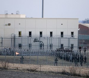 Security forces in riot gear surround a courtyard behind razor wire at the Tecumseh State Correctional Institution in Tecumseh, Neb., Thursday, March 2, 2017, where dozens of inmates congregated after refusing to return to their cells.
