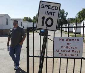James Womack, director of Hand Up Ministries, walks through the gate which has a sign prohibiting women or children inside the community, in Oklahoma City, Wednesday, Oct. 3, 2012. Hand Up Ministries is a non profit faith-based organization that offers help to men and women coming out of the prison system to re-enter society. The grounds currently house 150 sex offenders and 7 other felons.