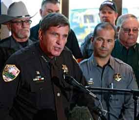 Weld County, Colo., Sheriff John Cooke, left, with El Paso County Sheriff Terry Maketa, center right, and other sheriffs standing behind him, speaks during a news conference at which he announced that 54 Colorado sheriffs are filing a federal civil lawsuit against two gun control bills passed by the Colorado Legislature.