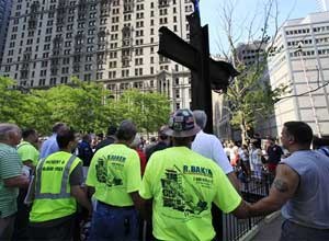 AP Photo/Mark Lennihan, File
World Trade Center construction workers hold hands during a prayer at a ceremony for the September 11 cross, in New York.