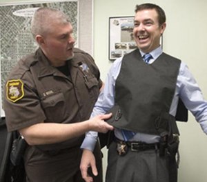 Corrections Officer Dave Bohl, left, straps a stun vest onto Saginaw County Sheriff William Federspiel, April 4, 2014.