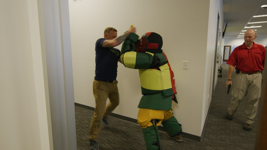 A participant practices defense moves against instructor Griffin.