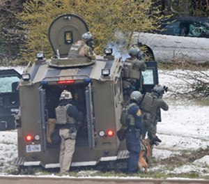 Phoenix SWAT team members prepare to move in on a house during a police standoff with an armed man in Phoenix on Friday, July 7, 2006. The man was wanted on a probation violation warrant.