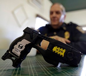 In this Nov. 14, 2013, file photo, a Taser X26 sits on a table in Knightstown, Ind.