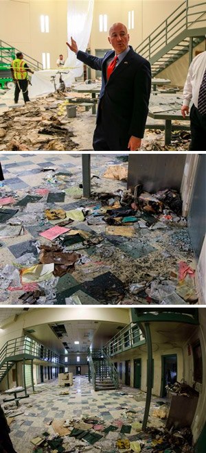 Nebraska Gov. Pete Ricketts points to workers cleaning up damage to housing unit 2, during a tour of the Tecumseh State Correctional Institution in Tecumseh, Neb., Tuesday, May 19, 2015. The tour took place a little more than a week after a riot at the prison left two inmates dead. At right is warden Brian Gage.
