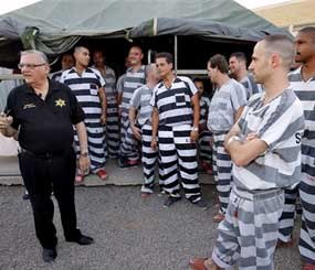Inmates gather next to Maricopa County Sheriff Joe Arpaio as he walks through a Maricopa County Sheriff's Office jail called