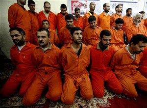 In this Dec. 2, 2010 file photo, handcuffed al-Qaida-linked suspects sit in the terrorist and organized crime department in Baghdad, Iraq.