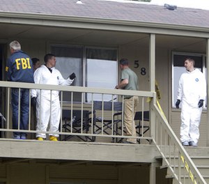 In this May 16 2013, file photo, Federal authorities search an apartment in Boise, Idaho.