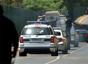 A vehicle believed to be transporting Oscar Pistorius, with police officers hanging on the sides, arrives at the Kgosi Mampuru Correctional Services prison in Pretoria, South Africa, Tuesday, Oct. 21, 2014. Pistorius was sentenced to five years imprisonment by judge Thokozile Masipais for killing his girlfriend Reeva Steenkamp last year. (AP Photo)