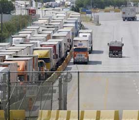 Freight trucks, center, breeze through a congested border check point using a Free and Secure Trade Lane, or FAST Lane, in Laredo, Texas, Wednesday, Oct. 14, 2009. The FAST Lane is part of the Customs-Trade Partnership Against Terrorism, or C-TPAT.