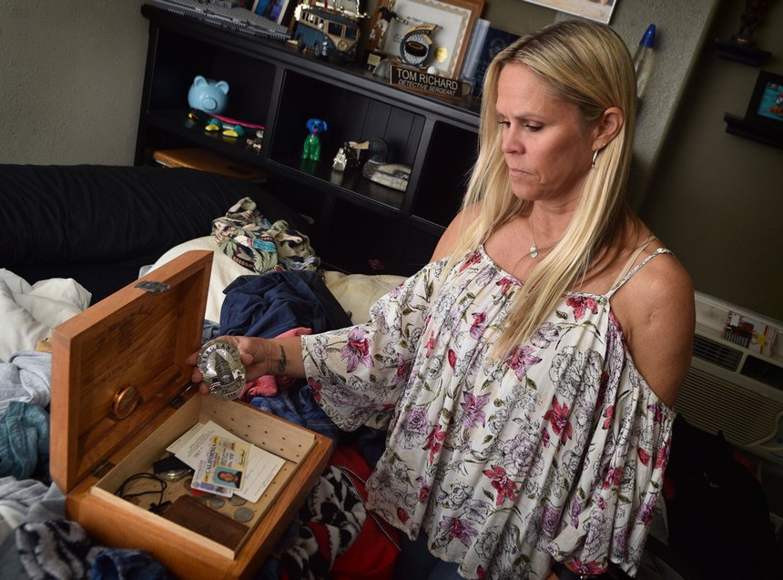 Carrie Richard goes through a box of some of her late husband’s belongings, including his Westminster PD sergeant badge. (Photo/Steven Georges/Behind the Badge)