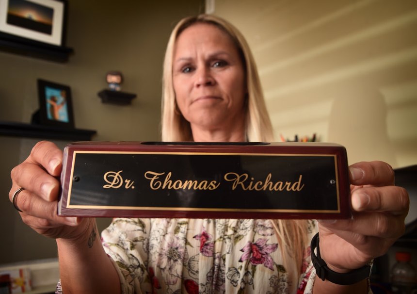 Carrie Richard holds her late husband’s nameplate, which would end up being her last Christmas gift to him. Tom earned a doctorate in psychology and was planning on opening a practice with two other retired peace officers to help cops suffering from PTSD and other mental illnesses. (Photo/Steven Georges/Behind the Badge)