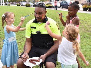 Lt. Matthew Johnson agrees to have his face painted by neighborhood children. (Photo/UMBPD)