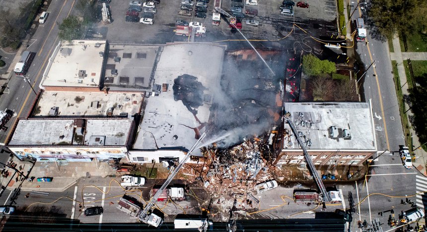 In this aerial photo, firefighters battle a fire at the scene of an explosion in Durham, N.C. Wednesday, April 10, 2019.