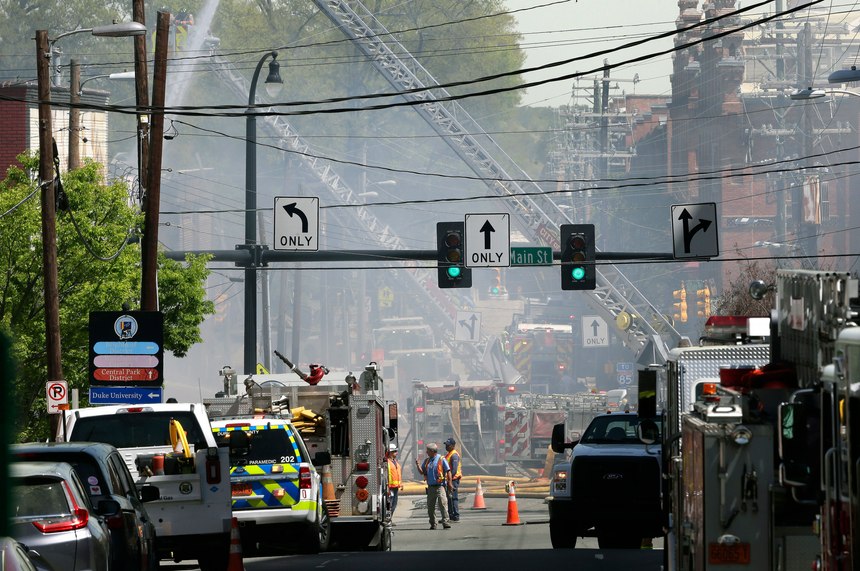 Firefighters and emergency personnel work the scene of a building fire in downtown Durham, N.C., Wednesday, April 10, 2019. Authorities say emergency officials responded to an explosion and fire possibly caused by a gas leak.