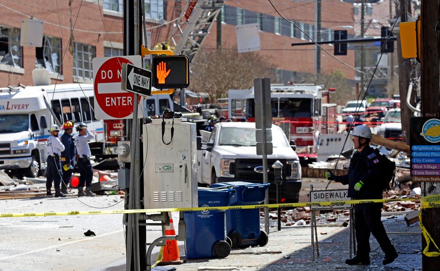 Firefighters and emergency personnel work the scene of a building fire in downtown Durham, N.C., Wednesday, April 10, 2019. Authorities say emergency officials responded to an explosion and fire possibly caused by a gas leak.