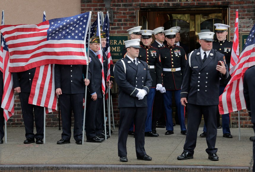 Service personnel prepare for the arrival of the body of Staff Sgt. Christopher Slutman in front of a funeral home in the Bronx borough of New York, Monday, April 22, 2019. Firefighters in three states are honoring the U.S. Marine and New York City firefighter who was killed by a roadside bomb in Afghanistan. (AP Photo/Seth Wenig)