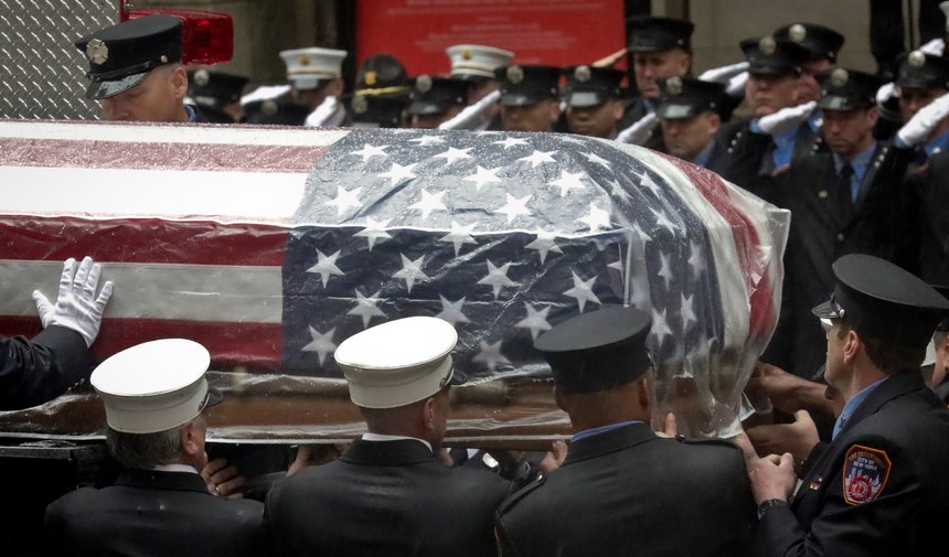 Firefighters hoist the casket of U.S. Marine Corps Staff Sergeant and FDNY Firefighter Christopher Slutman on to a firetruck, after funeral service at St. Thomas Episcopal Church, Friday April 26, 2019, in New York. (AP Photo/Bebeto Matthews)