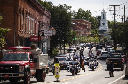 A memorial procession for Sgt. James Johnston, passes through Trumansburg, N.Y., Saturday, Aug. 31, 2019. (AP Photo/David Goldman)