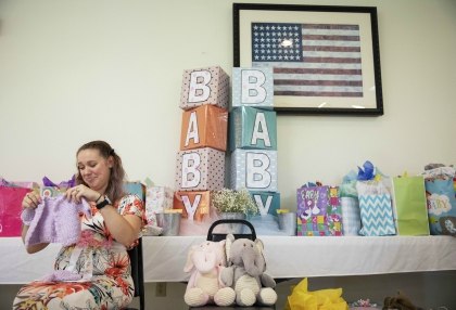 Krista Johnston opens gifts during a baby shower at the American Legion hall in Trumansburg, N.Y., Sunday, Sept. 1, 2019. (AP Photo/David Goldman)