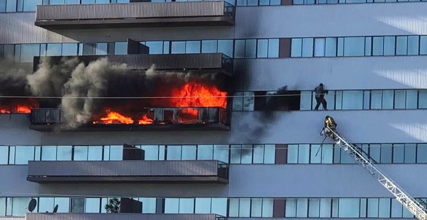 This image from video by Jenna Fabian shows a Los Angeles Fire Department firefighter on a ladder rescuing a man who had climbed out on the side of a 25-story high-rise apartment, escaping flames from a burning apartment balcony, after a fire broke out on a sixth-floor balcony and sent choking smoke billowing through the upper levels in West Los Angeles Wednesday, Jan. 29, 2020.