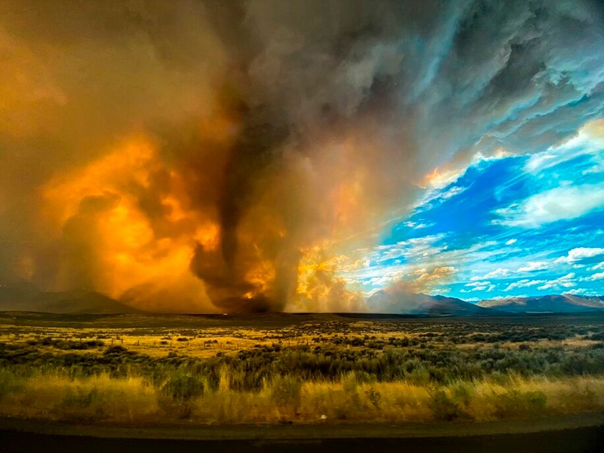 This photo provided by Katelynn & Jordan Hewlett, a funnel appears in a thick plume of smoke from the Loyalton Fire is seen in Lassen County, Calif., Saturday, Aug. 15, 2020. A wildfire in Northern California on Saturday spawned at least one fire tornado that prompted the National Weather Service to issue a tornado warning.