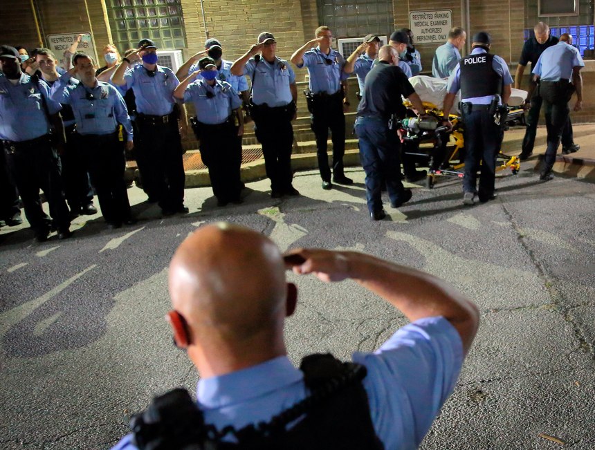 St. Louis police officers line up and salute as the body of fallen Officer Tamarris L. Bohannon is brought to the morgue in St. Louis, Sunday, Aug. 30, 2020.