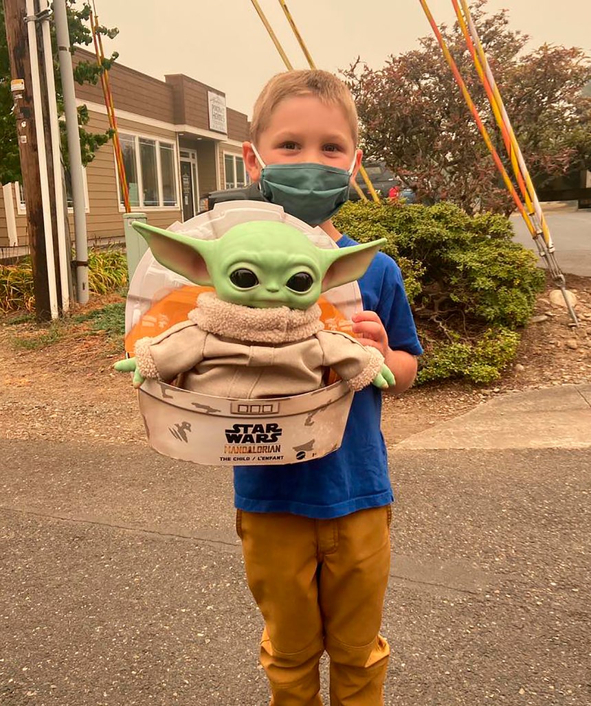 Five-year-old Carver holds up a Baby Yoda toy on Saturday, Sept. 12, 2020 in Scappoose, Oregon. Carver donated the toy to Oregon firefighters, who have been having fun posing the tiny green Force user on the fire lines since. Baby Yoda has traveled between fire crews across the Western United States, with his adventures documented on the Facebook page "Baby Yoda fights fires."