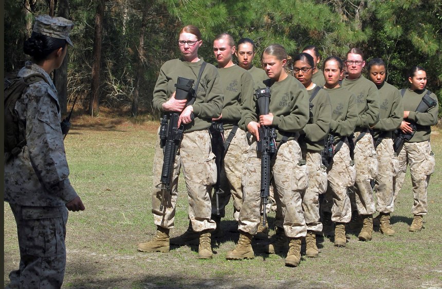 In this Feb. 21, 2013 file photo, female recruits stand at the Marine Corps Training Depot on Parris Island, S.C. New physical standards established so women can compete for combat posts in the Marine Corps have weeded out many of the female hopefuls. But data obtained by The Associated Press shows they’re also disqualifying some men. (AP Photo/Bruce Smith, File)