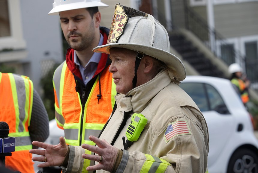 San Francisco fire chief Joanne Hayes-White gestures in front of Pacific Gas and Electric spokesperson Paul Doherty while speaking to reporters about a fire on Geary Boulevard in San Francisco, Wednesday, Feb. 6, 2019. (AP Photo/Jeff Chiu)