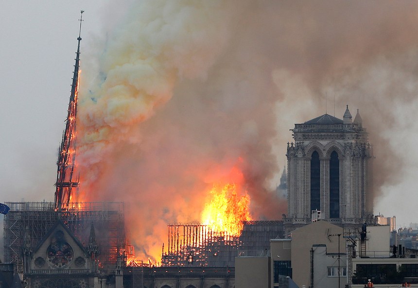 Flames rise from Notre Dame cathedral as it burns in Paris, Monday, April 15, 2019. Massive plumes of yellow brown smoke is filling the air above Notre Dame Cathedral and ash is falling on tourists and others around the island that marks the center of Paris.