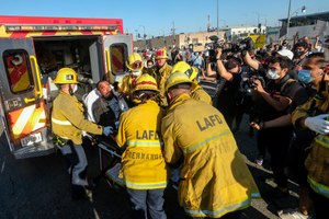 Los Angeles firefighters transfer a demonstrator, who was sitting on a police car and injured by falling onto the ground, to an ambulance during a protest.