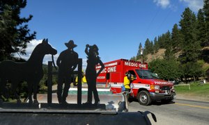 A western-themed mailbox sign is shown at left as a paramedic unit from King County's Medic One stands by on Twisp River Road in Twisp, Wash.