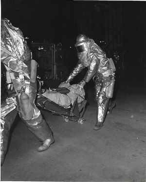 After practicing rescue of a fill-in astronaut, astronaut rescuemen move the subject to an M-113 personnel carrier parked at the base of the mobile launcher. Waiting at the M-113 is a Department of Defense medic with the equipment and medical skills to attend the flight crewmember. The Astronaut Rescue team practiced procedures that would be used in the event of a real emergency prior to the launch of Apollo 17.