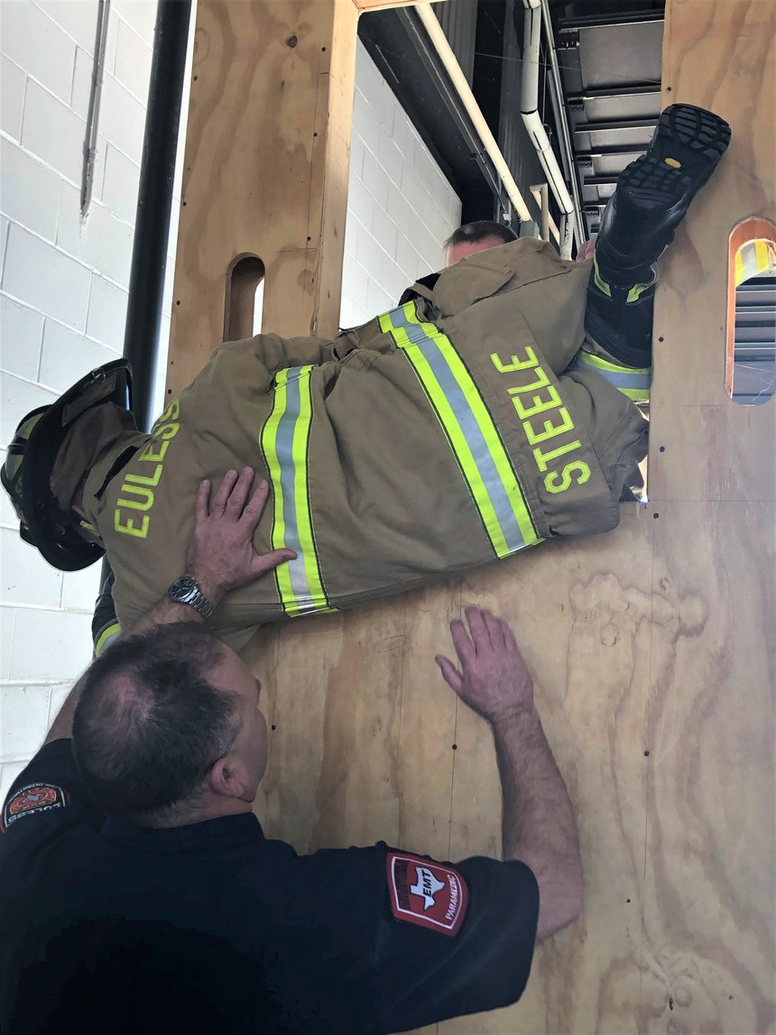 A captain works with a new firefighter on bailout procedures. Good training builds trust and confidence at all levels.