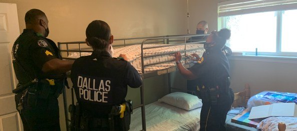 Dallas police officers, including McIntyre and Pesina, help assemble bunk beds for the family.