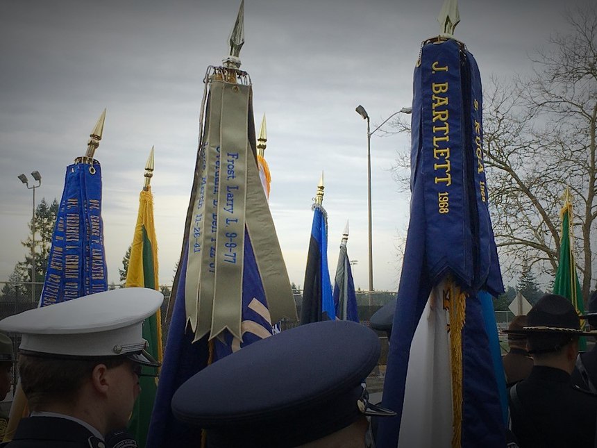 Officers representing public safety agencies from across the U.S. and Canada stand at attention to meet the procession at the memorial service for Pierce County Sheriff’s Deputy Daniel McCartney.