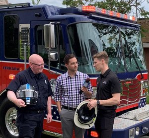 REV Group sponsored racecar driver Josef Newgarden and HEO Brian Cox engaged in a helmet exchange.
