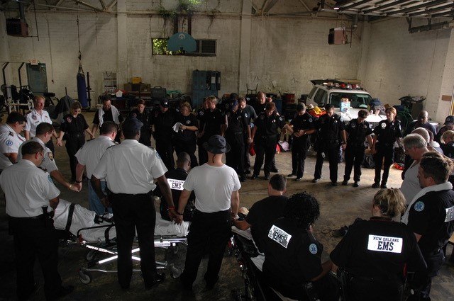 New Orleans Emergency Medical Services (formerly known as the New Orleans Health Department) professionals gather in prayer prior to assuming their post to await Hurricane Katrina landfall. (Photo/Miles Jeffery Watts, Jr.)