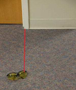The film plane is not parallel to the item of evidence so the viewer cannot see the true distance between the door frame and the item.