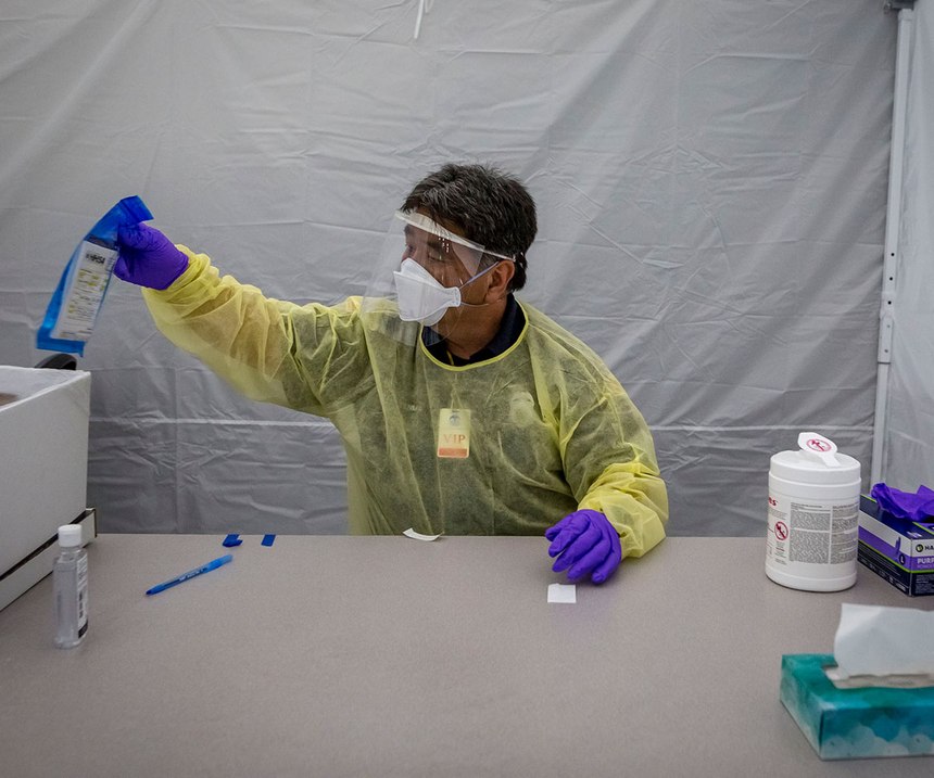 Craig Tenma, a paramedic for the San Diego Fire Department, bags a completed coronavirus test kit at Operation Shelter to Home in the San Diego Convention Center.