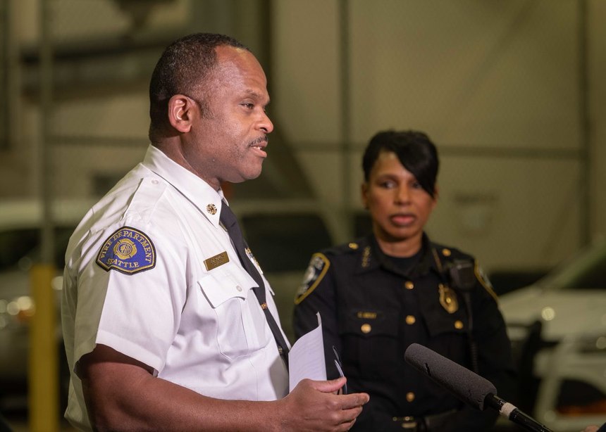 Fire Chief Harold Scoggins speaks to the media, with Police Chief Carmen Best standing by.