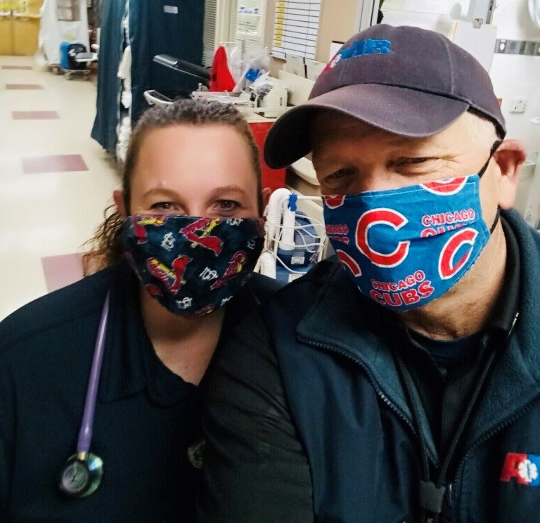 AMR EMT Stephanie Hatfield and Paramedic John Claspell wearing their baseball masks at the emergency department after dropping off a patient.
