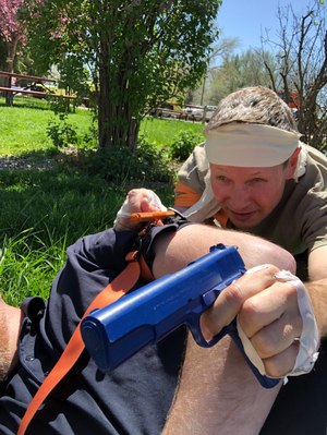 Having our hands taped to limit fingers made it more difficult to do everything, but we fought through. This officer, having been released from his blindfold, used my vest for cover after applying a tourniquet.