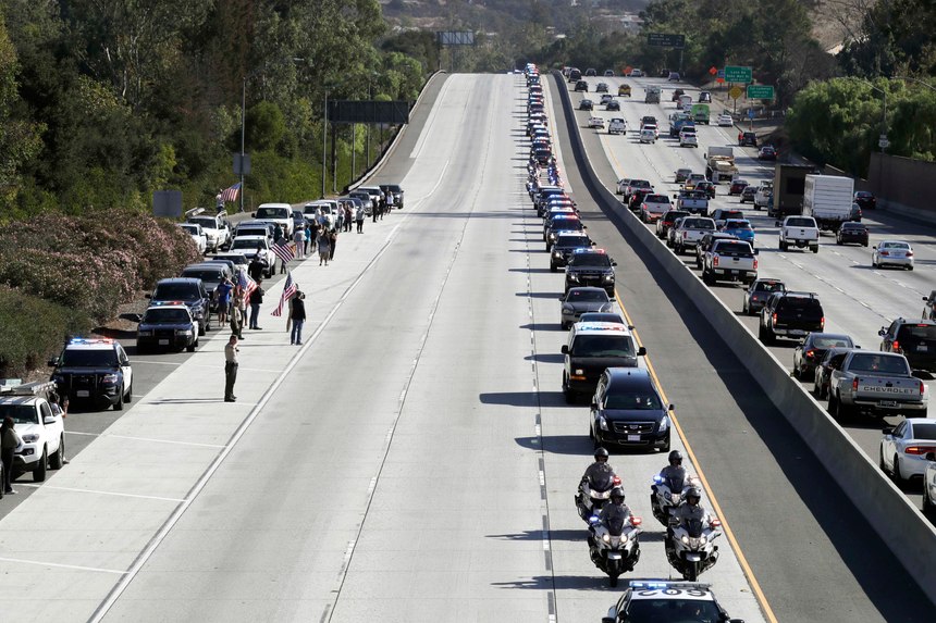 A law enforcement motorcade, providing an escort for a hearse carrying the body of Sgt. Ron Helus, makes its way northbound on Highway 101 Thursday, Nov. 8, 2018, in Newbury Park, Calif. Helus was fatally shot while responding to a mass shooting at a country music bar in Southern California.